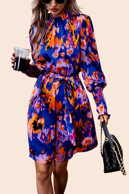 My Store abstract print mini dress with mock neck, voluminous sleeves, and waist tie worn by a woman with sunglasses.