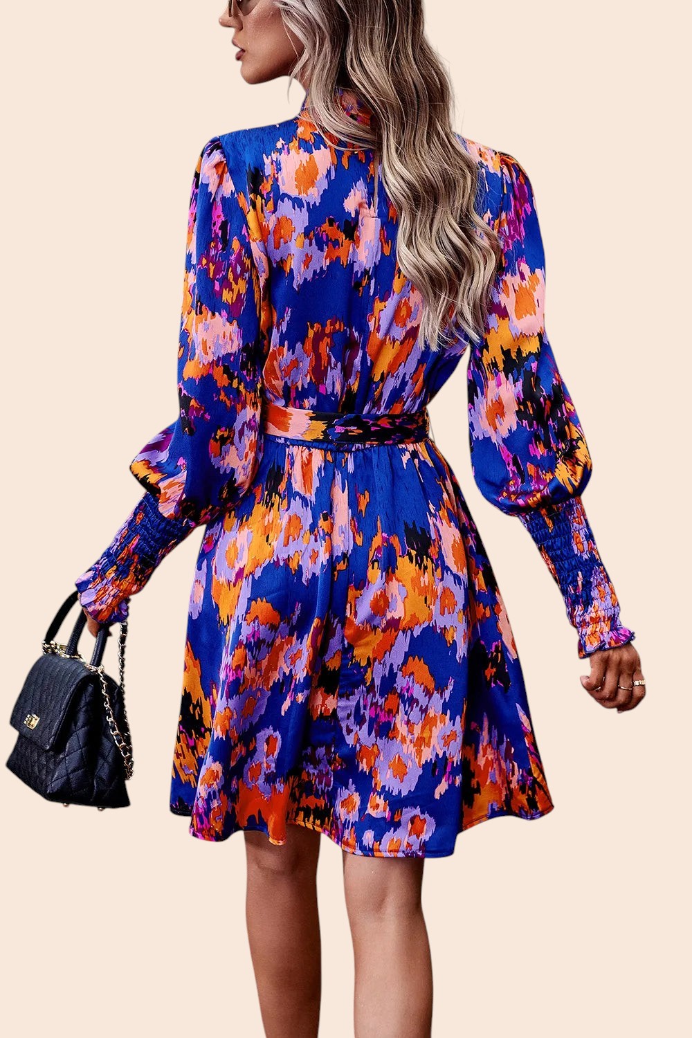 Back view of a My Store abstract print mini dress with long voluminous sleeves, smocked cuffs, and a waist tie.