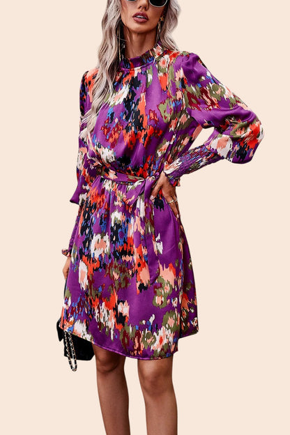 My Store abstract print mini dress with mock neck, long voluminous sleeves, and removable waist tie in purple tones.