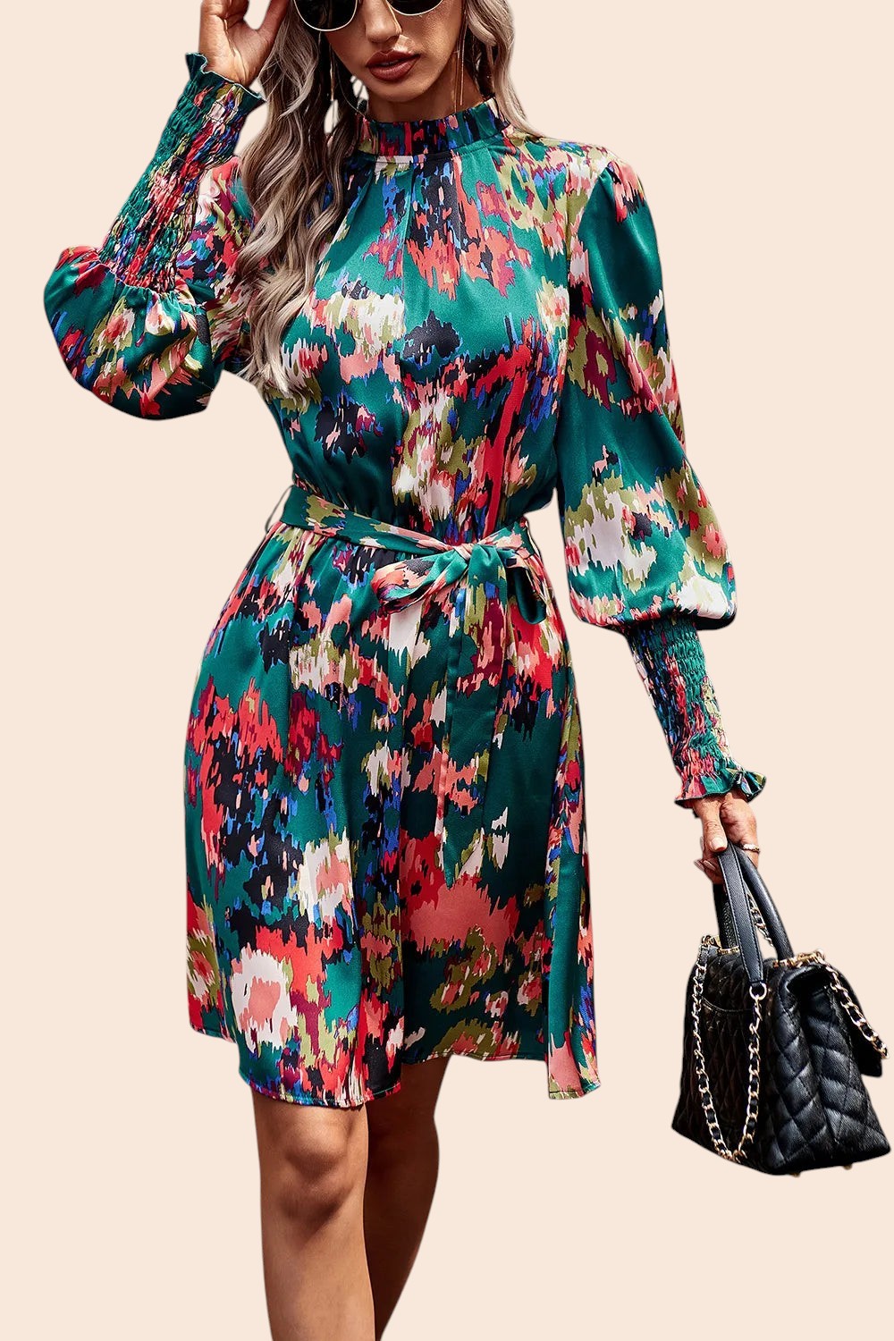 My Store abstract print mini dress with mock neck, voluminous sleeves, and waist tie worn by a woman with a handbag.