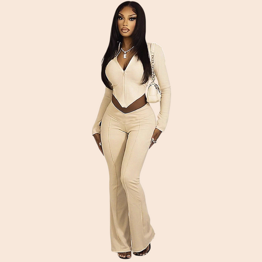 My Store apricot zip-up flare jumpsuit with long sleeves and a plunging V-neckline worn by a woman in a hallway.