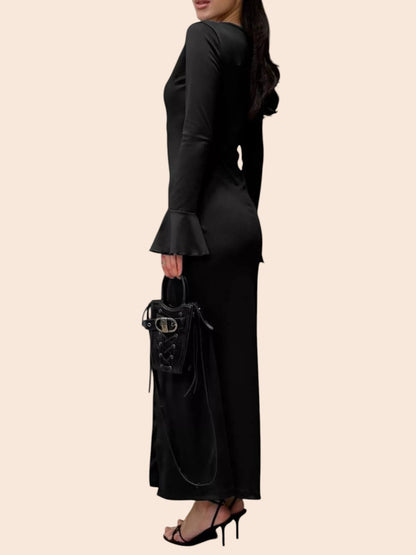 My Store black maxi dress with long flared sleeves and a side view silhouette, paired with a small black handbag.
