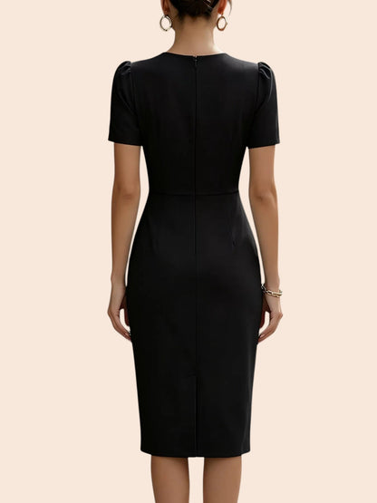 Back view of a My Store black midi dress with short sleeves, pleated waist, and a fitted pencil skirt silhouette.