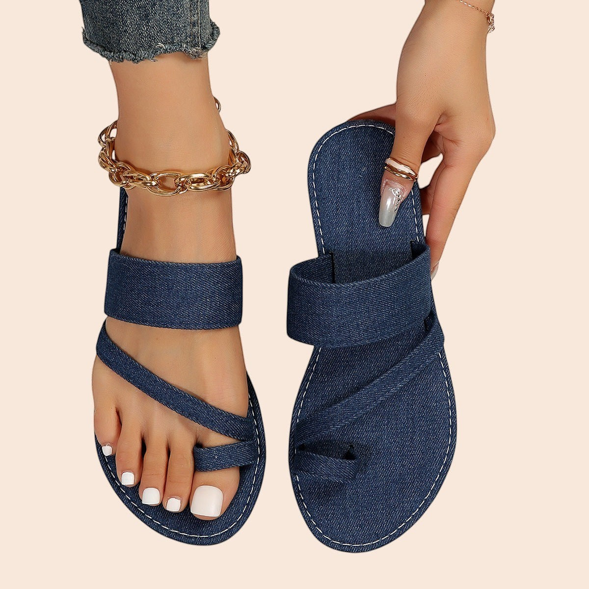 My Store blue denim toe loop sandals with textured crossover straps and flat sole. Model wears gold anklet.