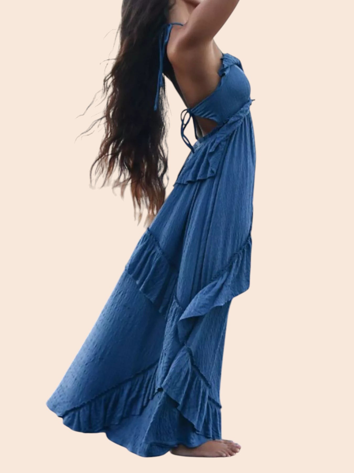 My Store blue ruffled tiered halter maxi dress with an open back, worn by a woman on a rocky beach at sunset.