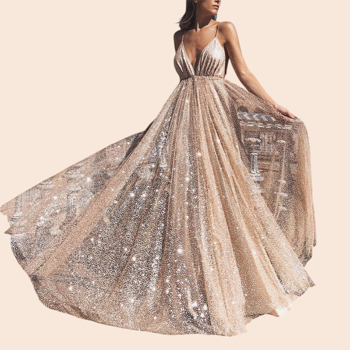My Store Aurelia gold shimmer maxi gown with a deep plunging neckline and full skirt worn outdoors at a plaza.