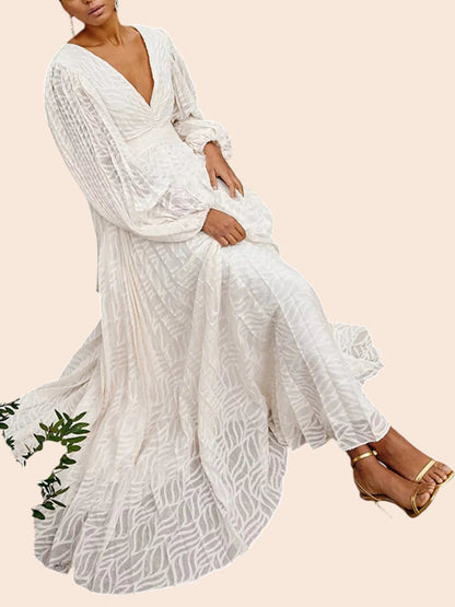 My Store white maxi dress with leaf texture, V-neckline, and balloon sleeves, worn by a model sitting outdoors.