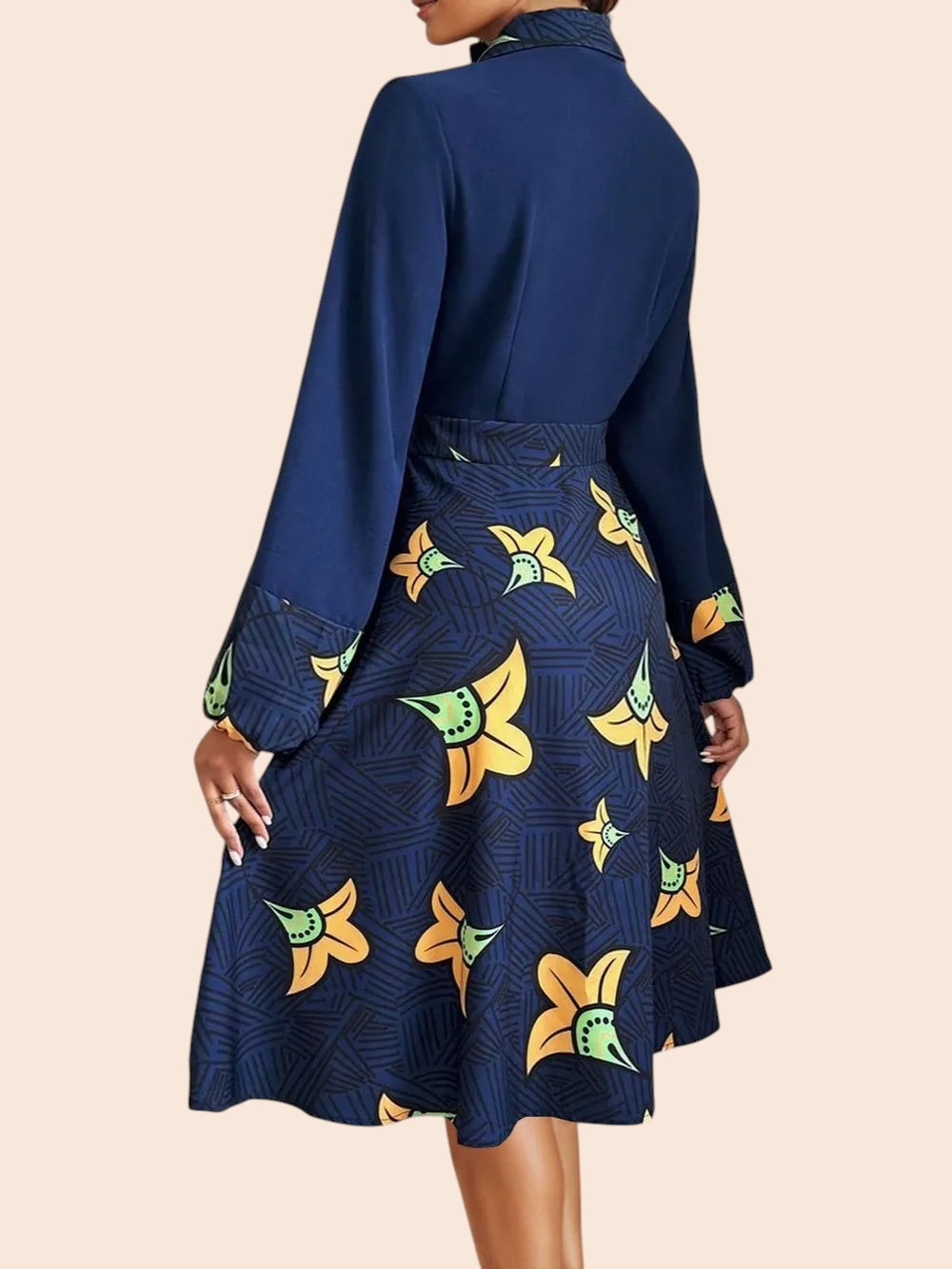 Back view of a My Store navy midi shirt dress with long sleeves, a collared neck, and a yellow floral A-line skirt.