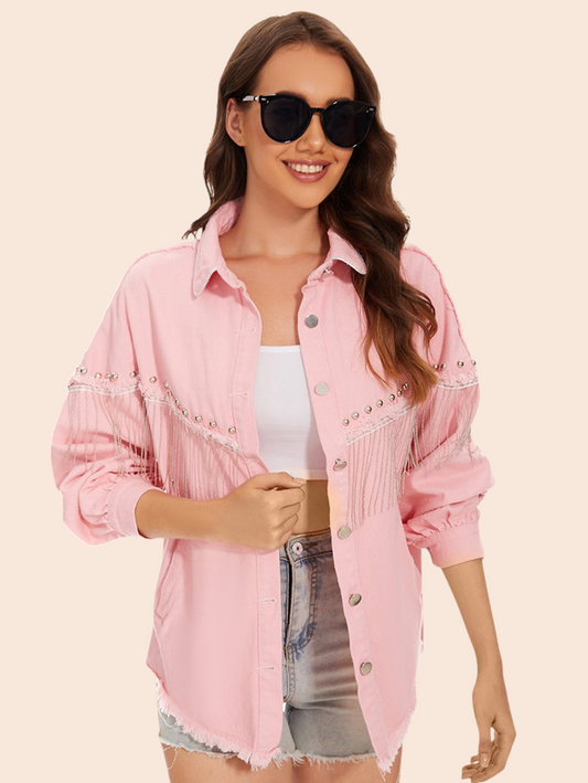 My Store pink denim jacket with fringe detailing, silver studs, and a raw hem worn by a smiling woman in sunglasses.