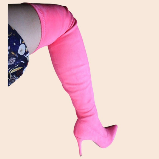 My Store bright pink stretch suede thigh-high stiletto boots with a pointed toe and slender heel on a model's leg.