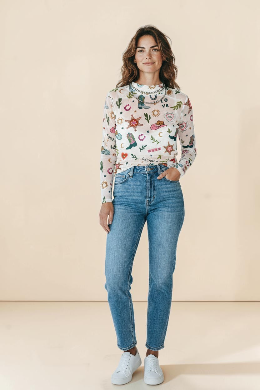 My Store white sheer mesh top with a western print featuring cowboy boots, hats, cacti, suns, moons, and hearts. Slight stretch, 95% polyester, 5% elastane.