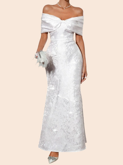 My Store white off-shoulder maxi dress with a statement bow bodice, textured fabric, and elegant flared hem.