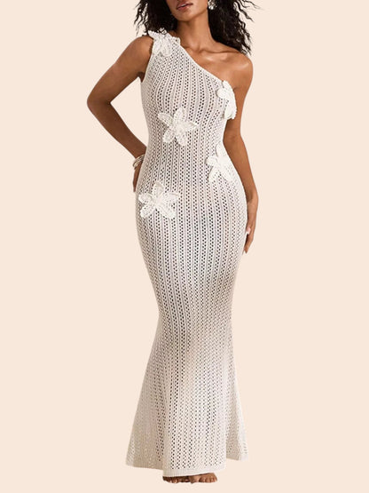 My Store white crochet maxi dress with one-shoulder neckline and dimensional floral appliqué details on a sandy beach