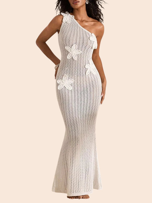 My Store white crochet maxi dress with one-shoulder neckline and dimensional floral appliqué details on a sandy beach