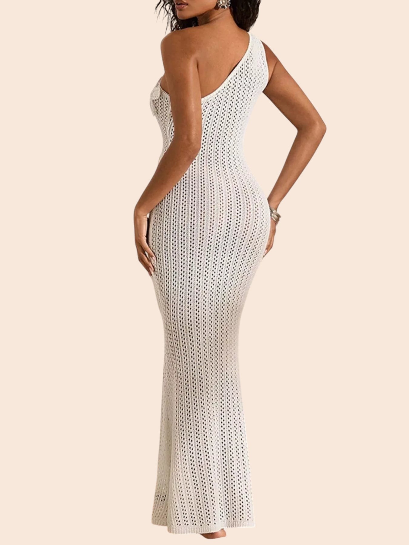 My Store white one-shoulder crochet maxi dress with floral appliqué and openwork detail on a model in a sandy setting.