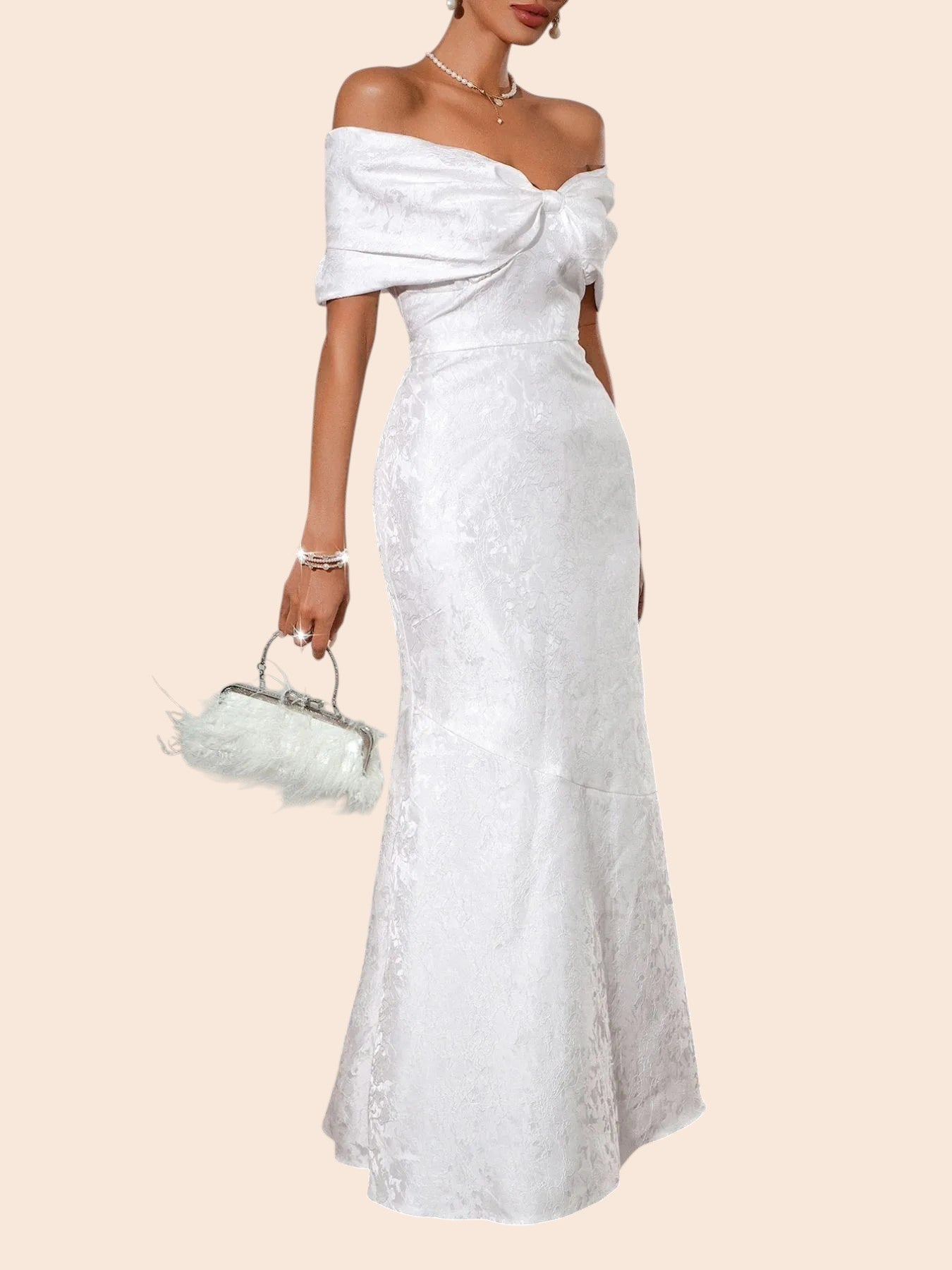 My Store white off-shoulder maxi dress with a statement bow bodice and textured fabric, styled with a feathered clutch.