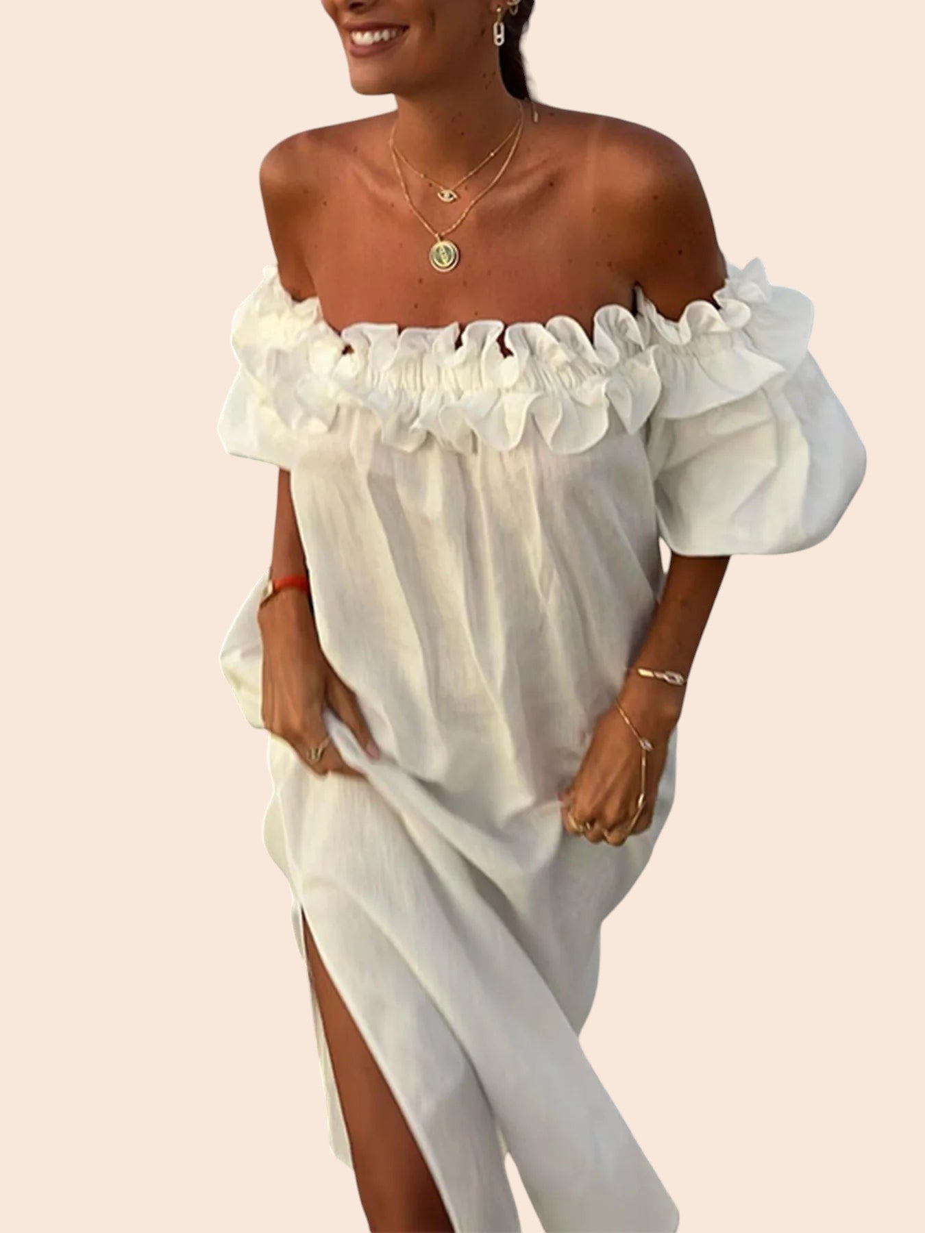 My Store white off-shoulder maxi dress with ruffled neckline and side slit worn by a woman on the beach
