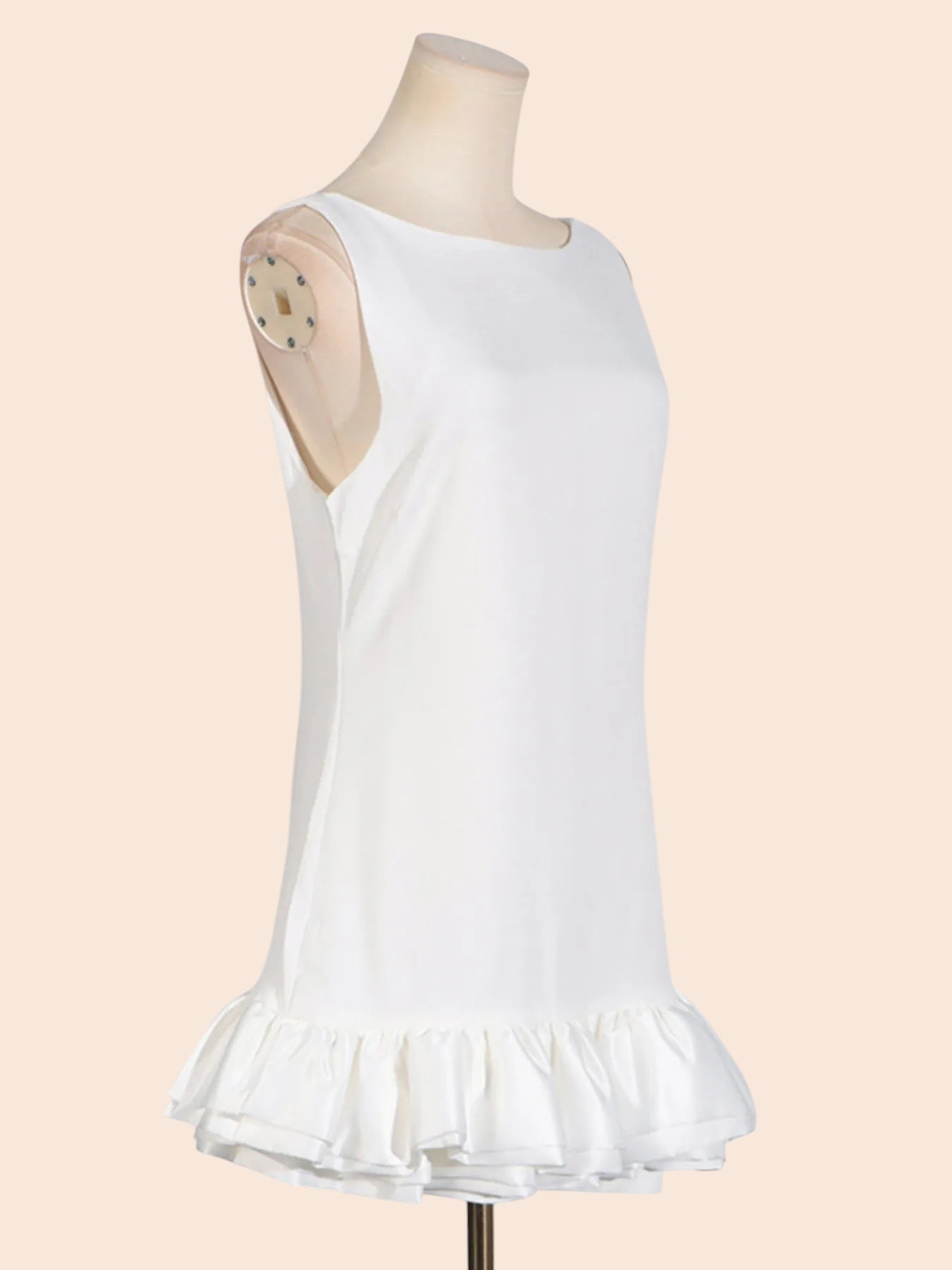 My Store white sleeveless mini dress with a round neckline and a sculpted layered ruffle hem on a mannequin