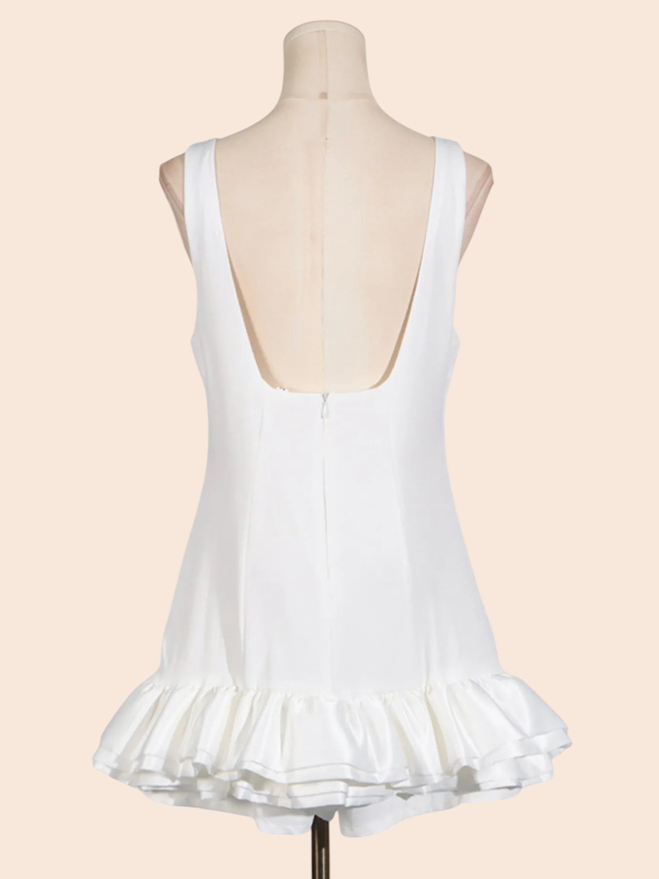 My Store white sleeveless mini dress with a low back and a sculpted layered ruffle hem on a mannequin
