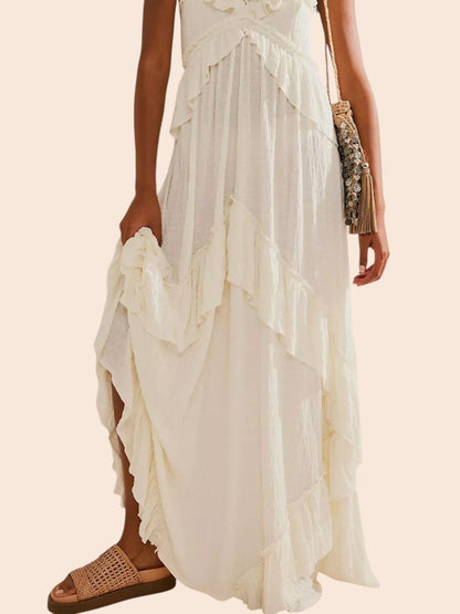 My Store white ruffled tiered halter maxi dress with a flowing silhouette and open back, styled with woven sandals.